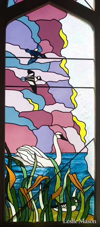 a hawk and a mallard in flight over a swan