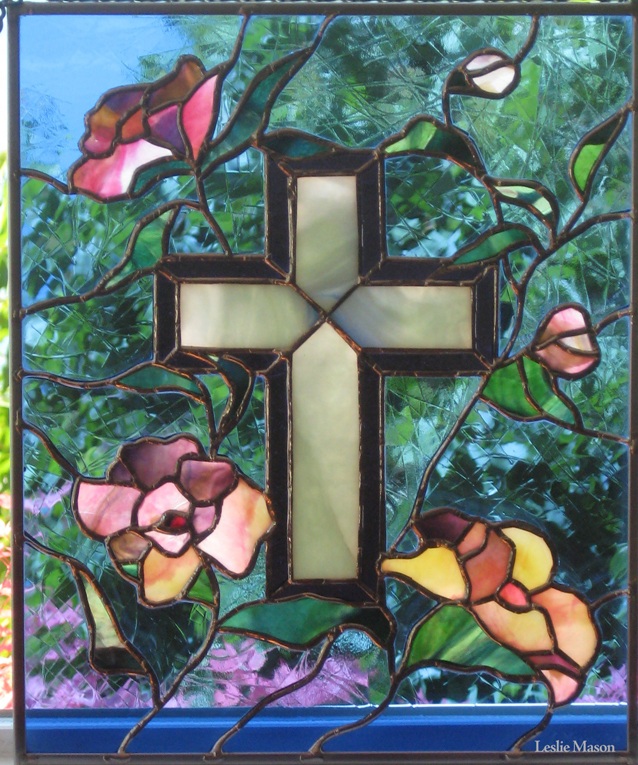 a cross surrounded by budding flowers